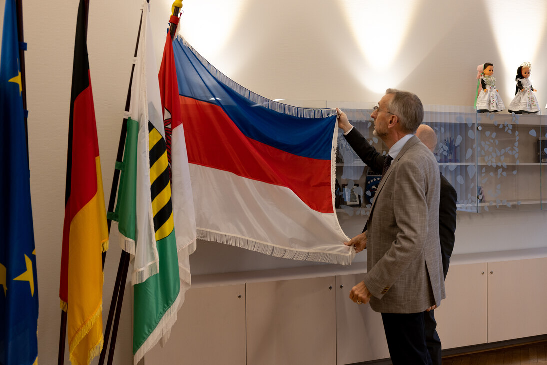 Innenminister Armin Schuster beschaut die Fahne der Sorben