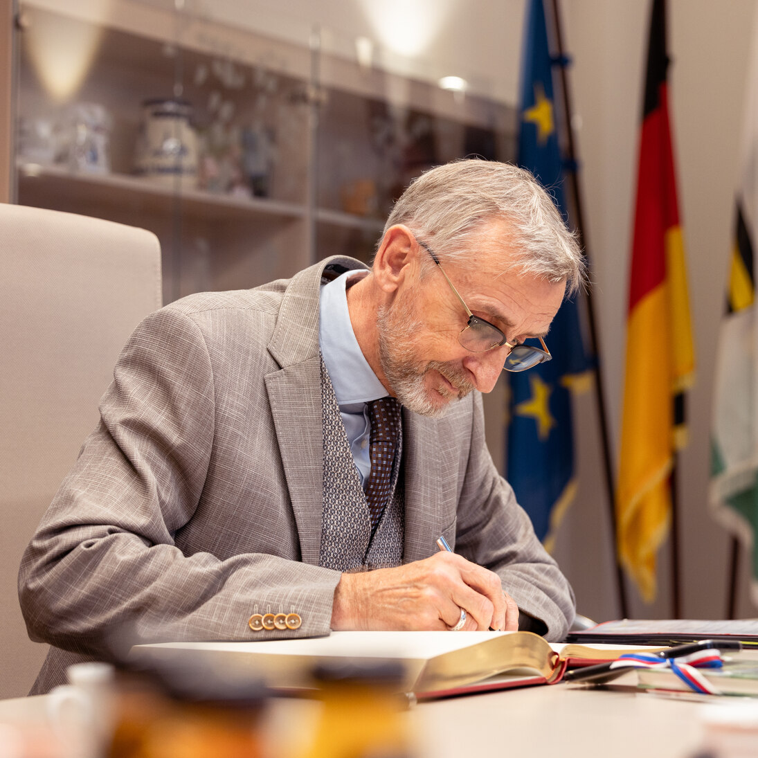 Innenminister Armin Schuster trägt sich ins Goldene Buch ein